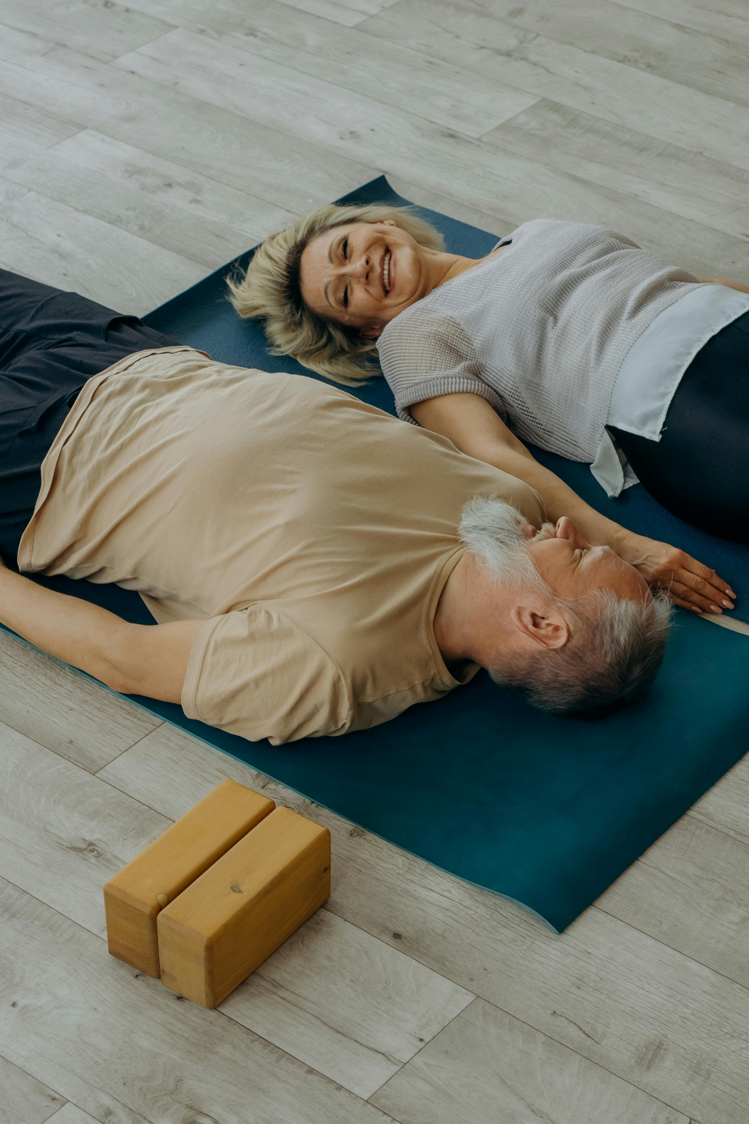 Frau und Mann liegen auf Yogamatten auf dem Boden